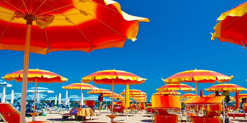 La spiaggia di sabbia fine di Lido di classe risulta accogliente con i suoi ombrelloni e lettini colorati.