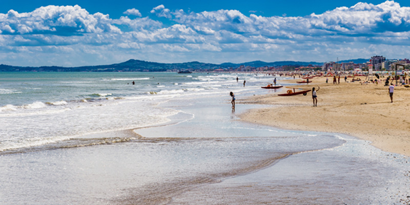 La grande spiaggia dorata di Milano Marittima abbraccia le onde del mare 