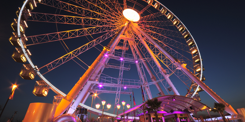 Una ruota panoramica illumina la notte di Riccione, splendida località adatta sia per giovani che per famiglie.