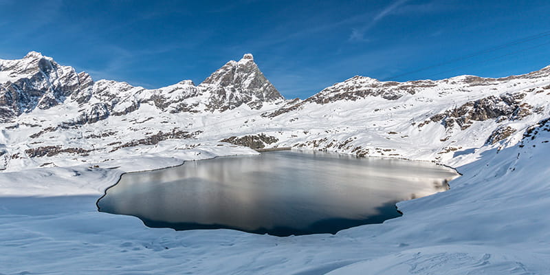 Lago ghiacciato di Goillet, si trova poca sopra la località sciistica di Breuil-Cervinia. Un gioiello incastonato tra le montagna bianche, raggiungibile da Breuil-Cervinia praticando trekking.