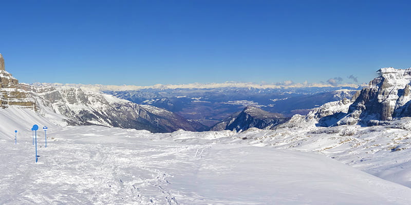 Una pianura innevata si affaccia su il panorama straordinario delle montagne che circondano la famosa zona di Madonna di Campiglio.